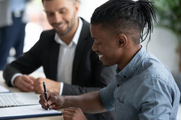 man signing a document