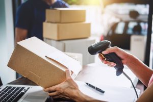 closeup of a woman holding a package and scanner
